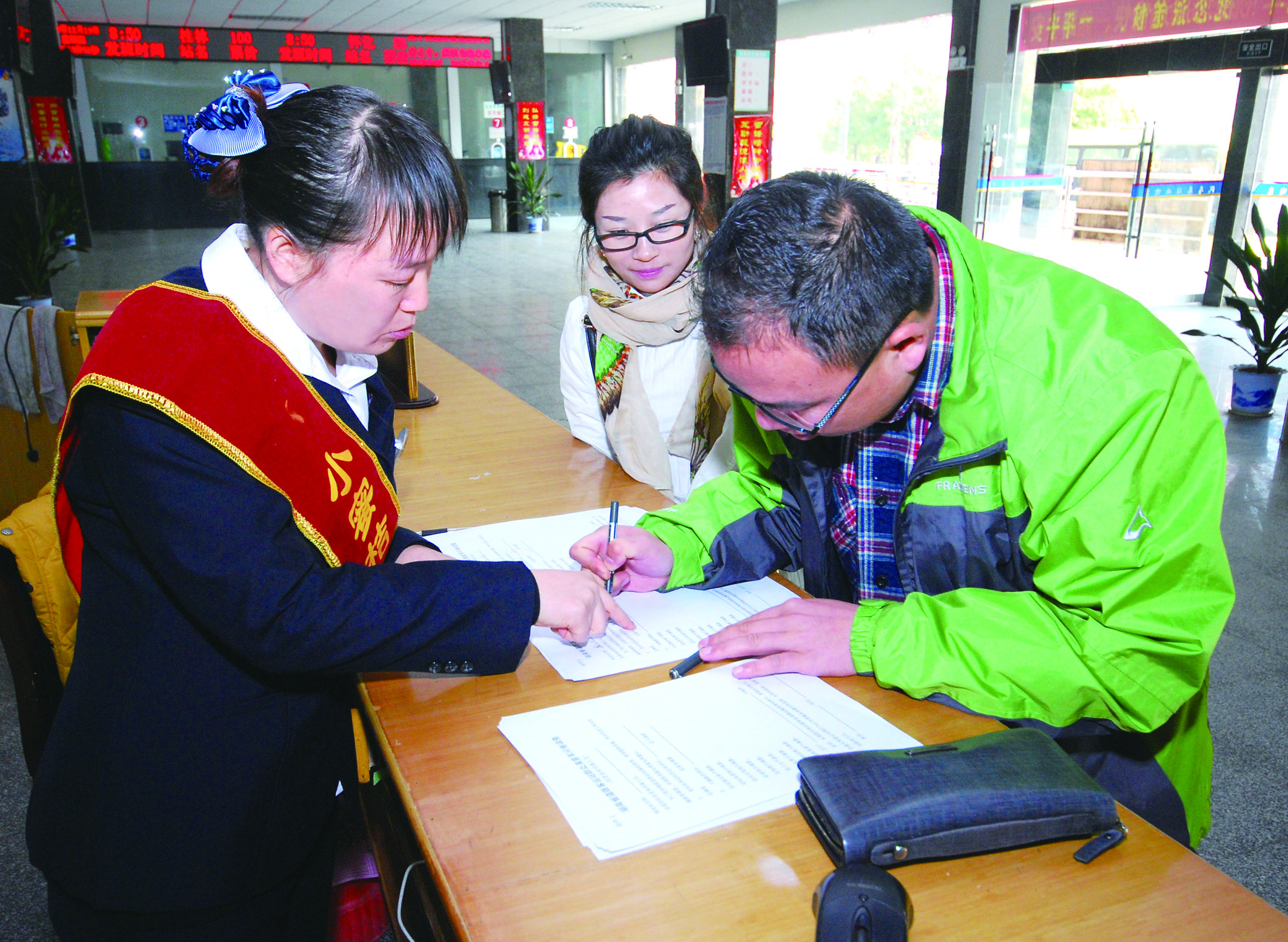 圖為洞口汽車總站站務(wù)人員在熱心為旅客服務(wù)。